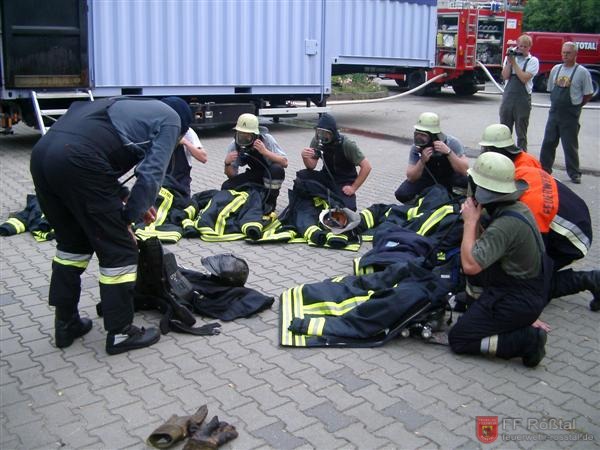 Bild 19 von 20 Brandübungscontainer: Die Überjacken werden unter Atemschutz ausgeschüttelt, um die Belastung der Teilnehmer mit Atemgiften gering zu halten.