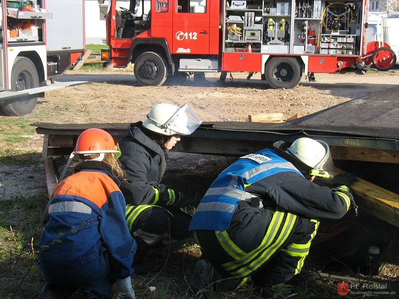 Bild 4 von 16 Unter diesem Holzhaufen soll sich ein Pkw mit einer eingeklemmten Person befinden